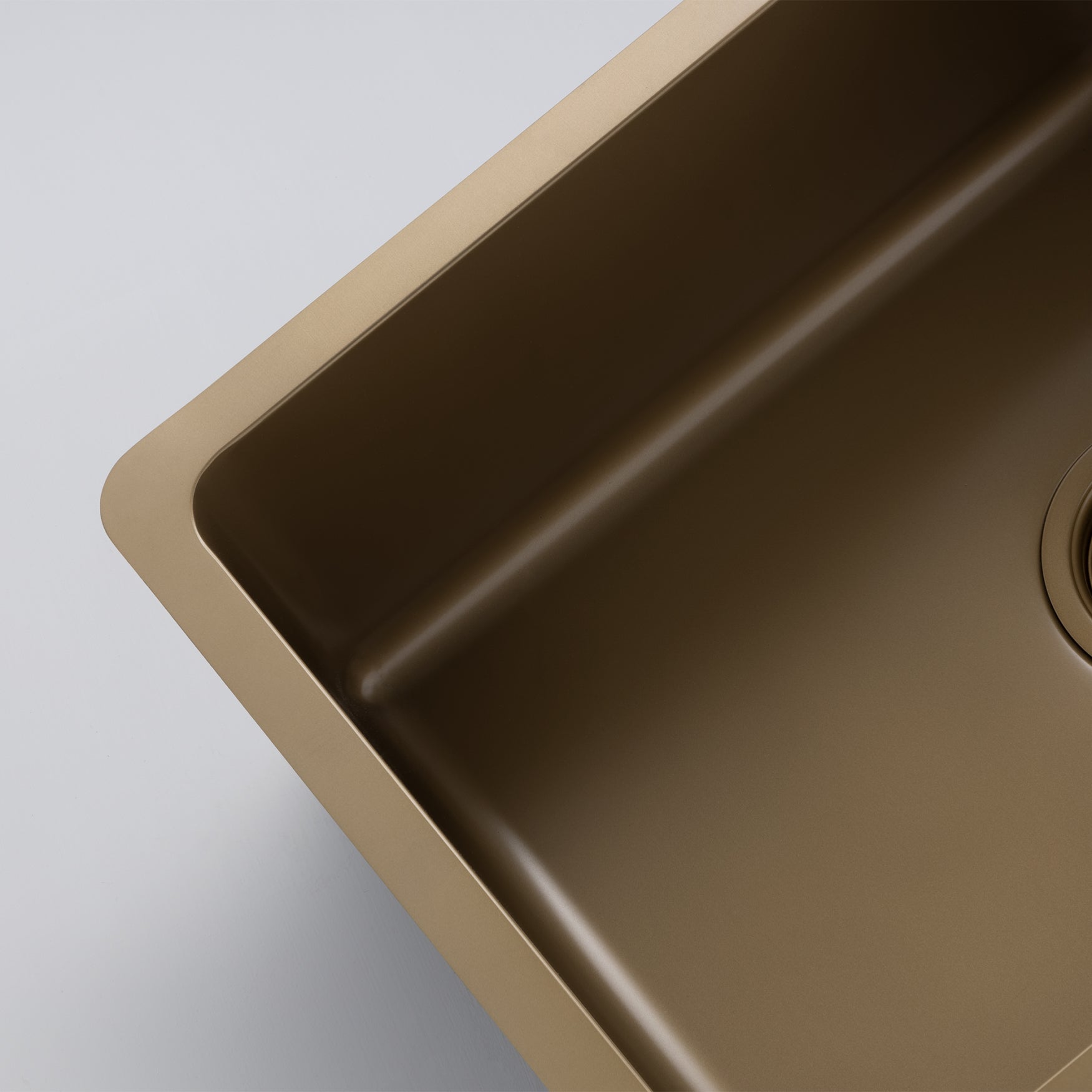 Close-up still life image of a Titan large bowl pearl gold sink against a gray background, highlighting the elegant design of the brass sink.